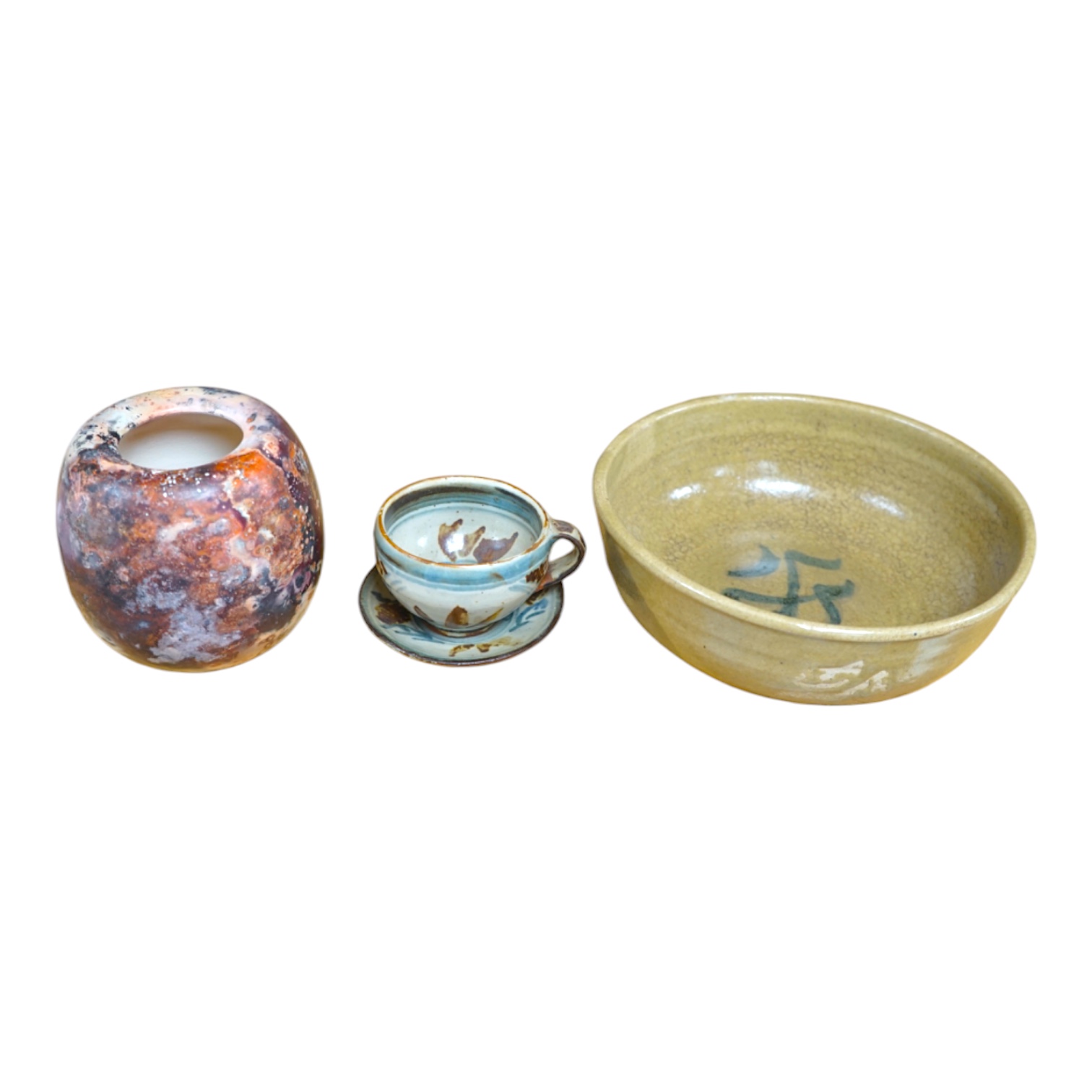Three pieces of glazed studio pottery comprising a bowl, vase, and a cup and saucer by Seth Cardew, stamped to the base, largest 19cm in diameter. Condition - good